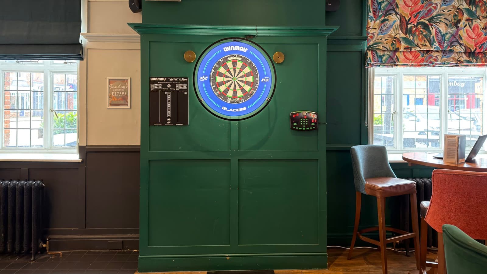 Dart board corner inside The Old School House showing the traditional pub-games setup.