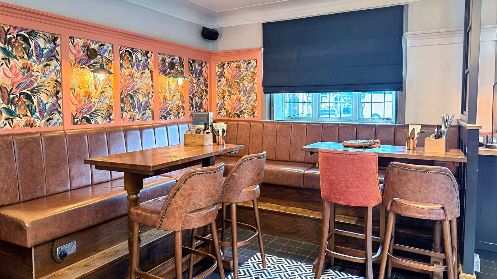 Main indoor seating area inside The Old School House with exposed brick and timber furniture.