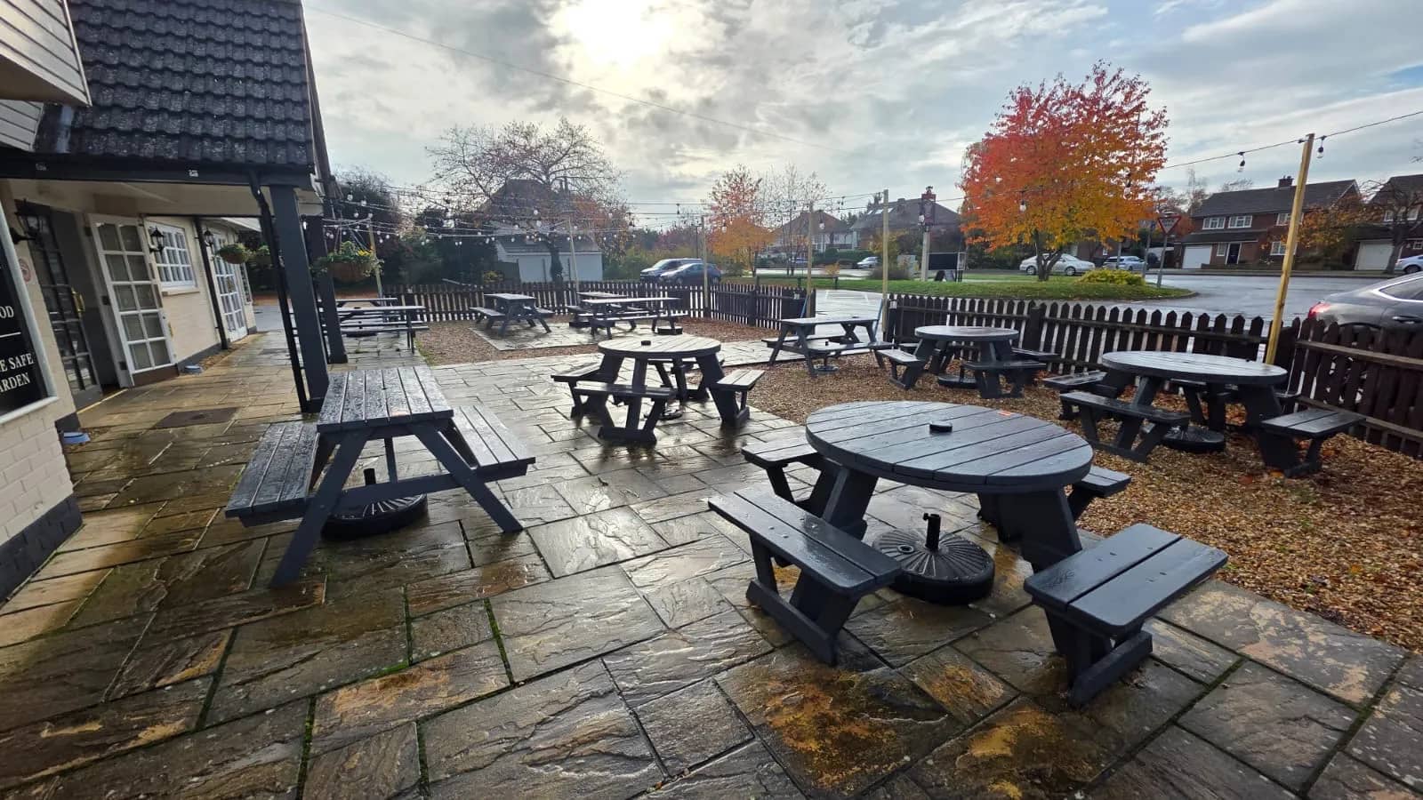 Prince of Wales beer garden with picnic tables, festoon lights, and lawn seating.