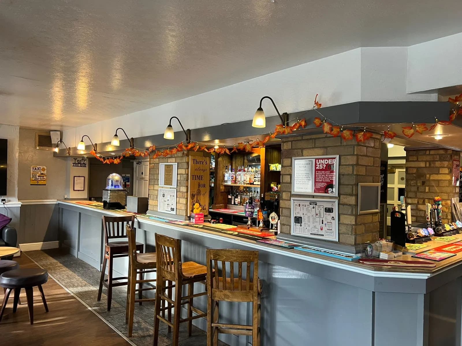 Side view of the bar showing timber paneling, mirrors, and ale taps.