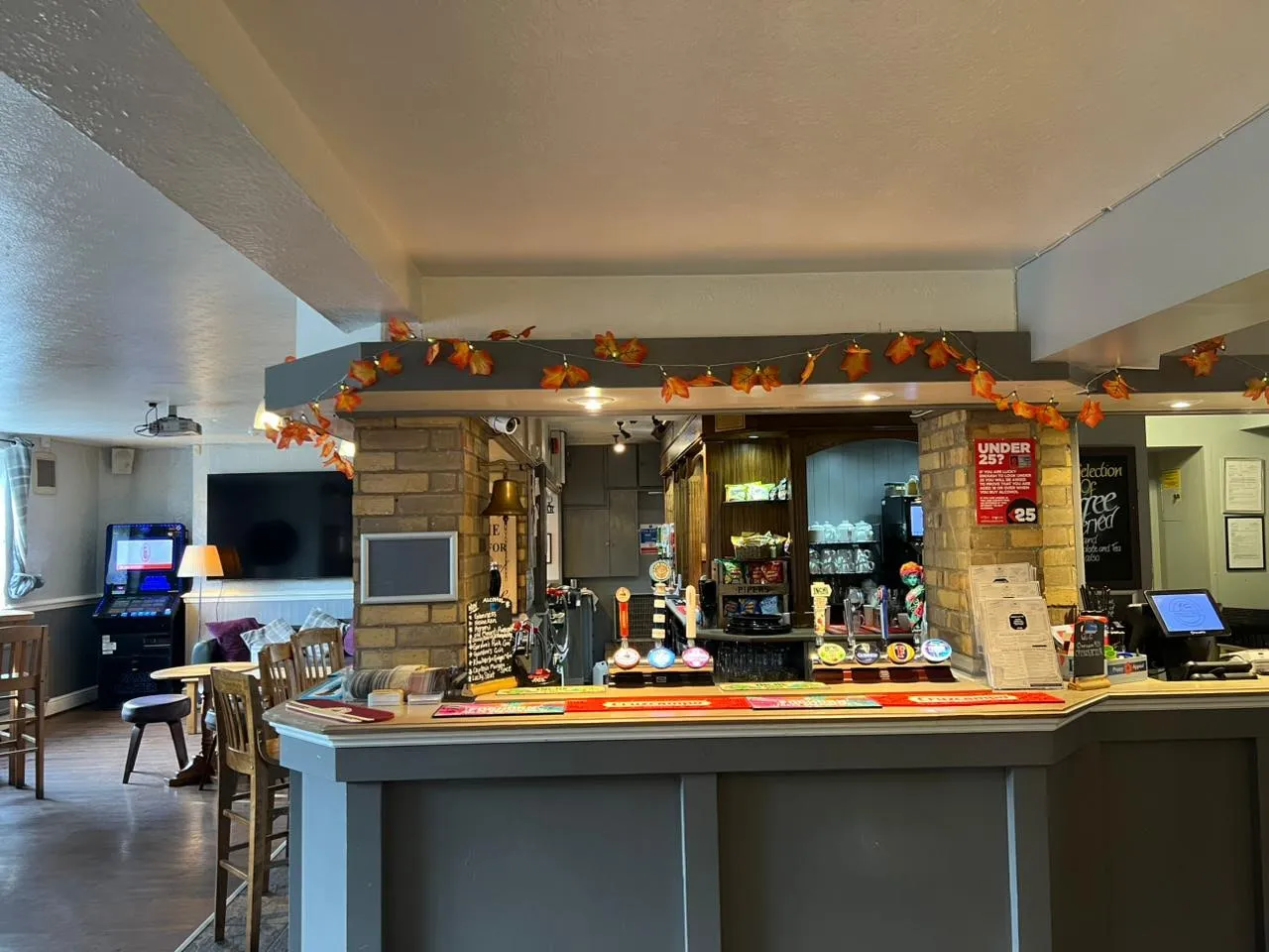 Main bar area with polished timber counter, spirits shelves, and bar stools.