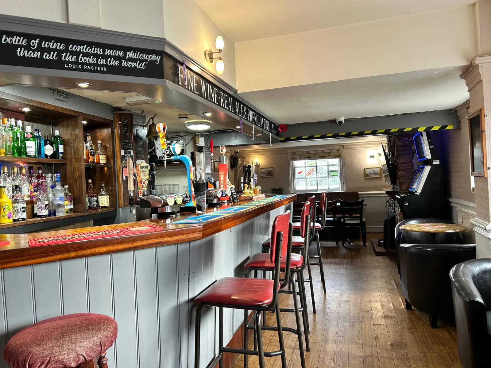 Alternate bar seating view with tufted benches, pendant lights, and framed art.