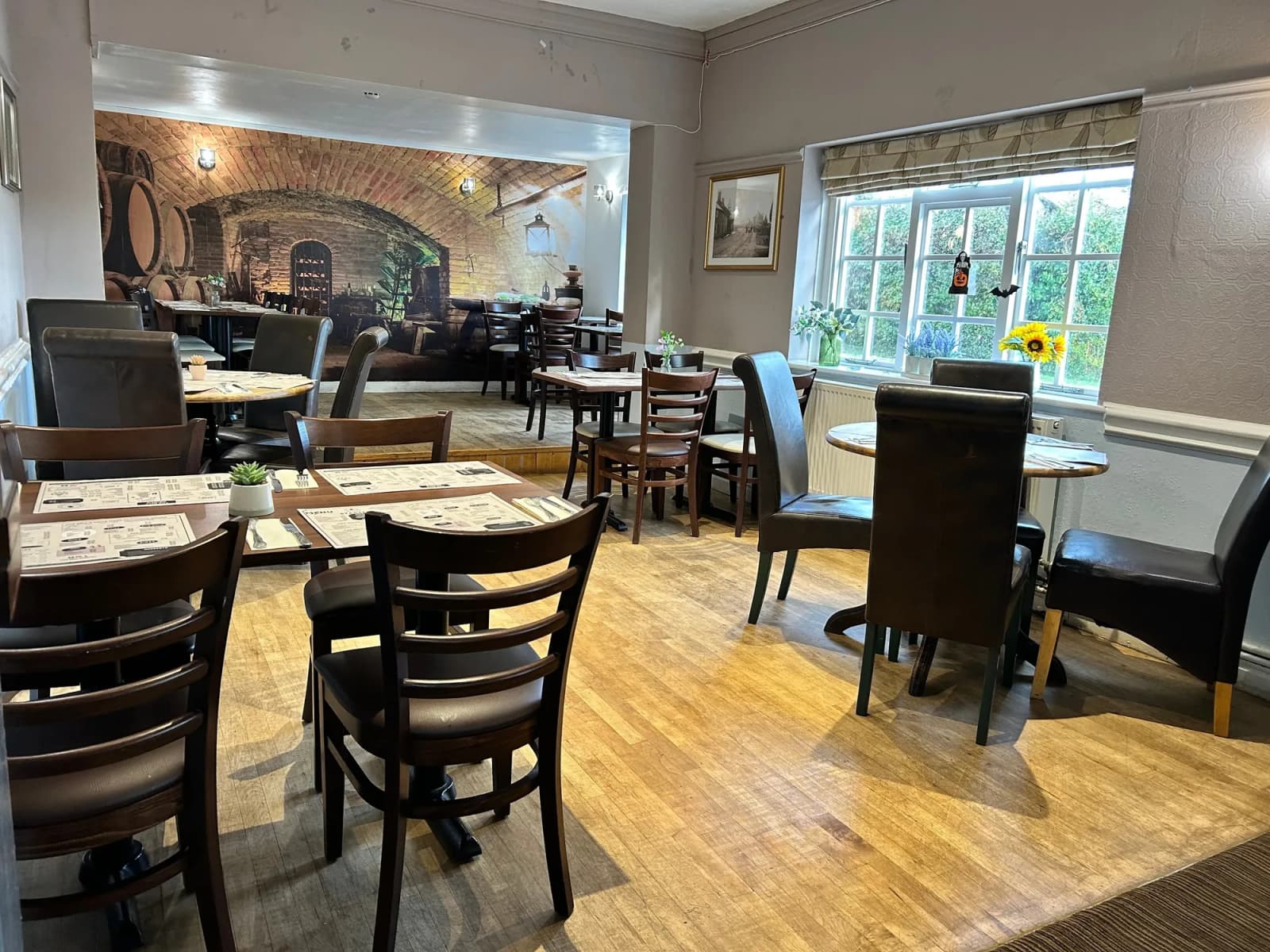 Dining room view showing banquette seating, mirrors, and warm lighting.