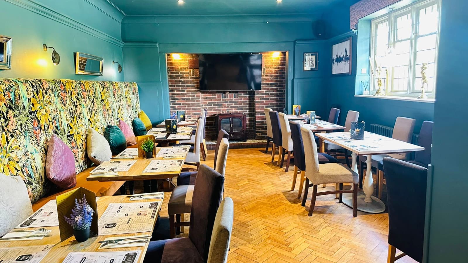 Art Deco dining room at The Old Crown with velvet banquettes and set tables.