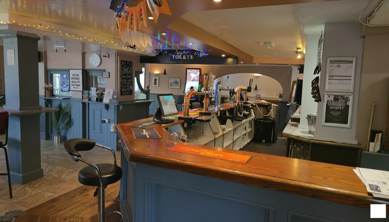 Backlit main bar counter at The Queen Elizabeth with handpulls and purple accent lighting.