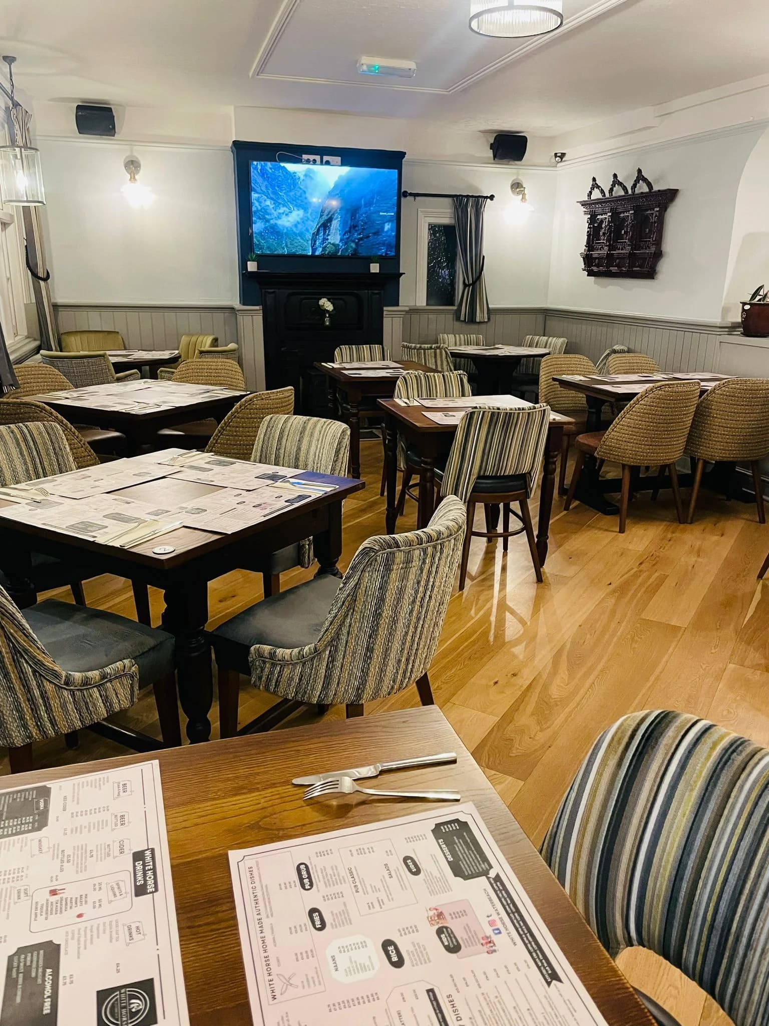 Dining room with televisions and timber tables at The White Horse.