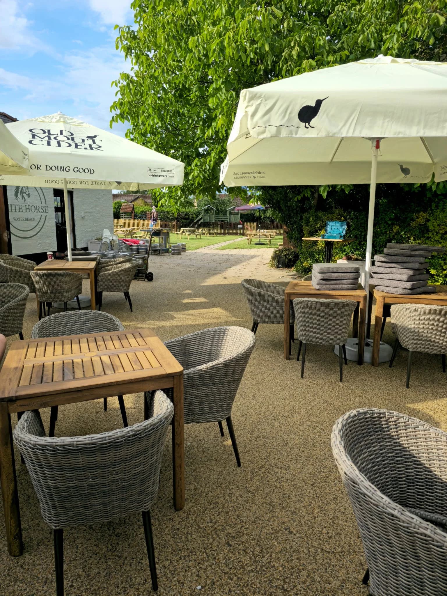 Patio terrace with wicker chairs, parasols, and planters.